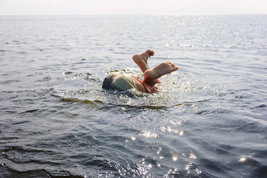 Teenager having fun swimming and splashing in the sea outdoors