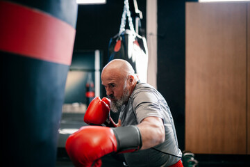 Man boxing with red gloves during training at gym showing focus and energy