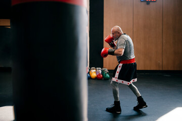 Boxer training with red gloves in a gym during athletic preparation