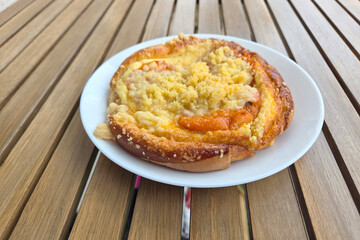 Freshly Baked Apricot Streusel Pastry on White Plate for a Delightful Breakfast Setting