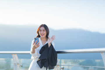 Confident Asian businesswoman smiling in a modern corporate setting, attractive professional lady standing outdoors, showcasing success, beauty, career ambition, and cheerful lifestyle.