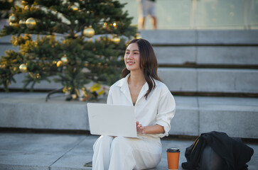 Confident Asian businesswoman smiling in a modern corporate setting, attractive professional lady standing outdoors, showcasing success, beauty, career ambition, and cheerful lifestyle.