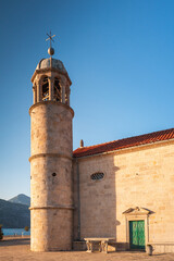 Fototapeta premium The side of the church of our lady of the rocks in Perast at sunset. Bay of Kotor. UNESCO Natural and Culturo-Historical Region. Montenegro.