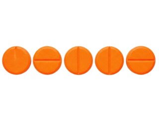 Isolated orange pills in a row, tablet split into halves, medicine for health and wellness