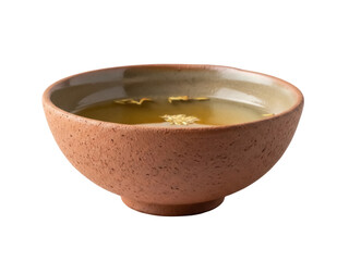 Isolated earthen bowl of herbal tea showing dried herbs floating on surface, a natural remedy
