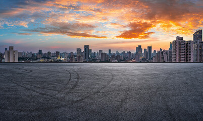 Empty asphalt road and city skyline with modern buildings at sunset in Shanghai