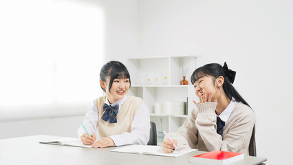 部屋で勉強する二人の女子学生