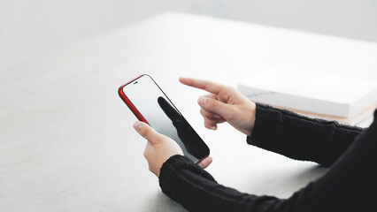 部屋でスマホを使う女性