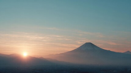 Landscape photograph of a city with a mountain in the background. the sky is a beautiful shade of blue with the sun setting on the left side of the image.