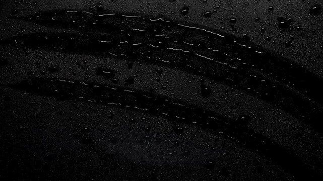 Intense rain washing over window with lightning flashing in dark background. Atmospheric storm overlay for video editing. Seamless loop