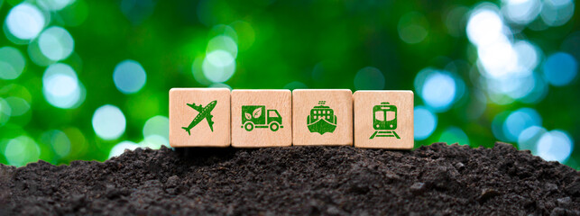 Transportation icons on wooden blocks amidst natural terrain. Eco-friendly logistics, emphasizing Net Zero goals for air, road, sea and rail transport.