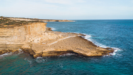 Scenic Malta coastline with rocky cliffs and azure waters.