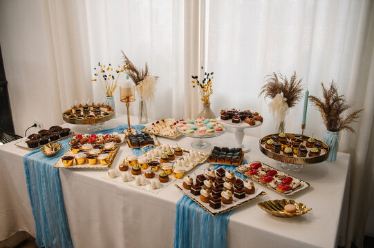 Delicious reception for birthday party or baptism. Lollipops. Wedding candy bar. Celebration concept. Table with sweets, candies, and dessert.