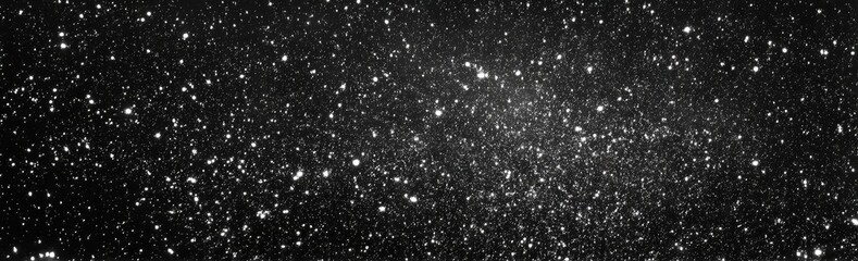Obraz premium A dark monochrome gradient background features countless tiny, glittering white speckles