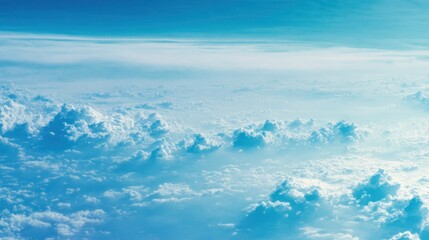 Obraz premium Aerial view of beautiful puffy clouds in a blue sky, creating a dreamy and serene atmosphere