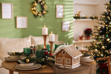 Festive table setting with beautiful gingerbread house and Christmas decor indoors, closeup