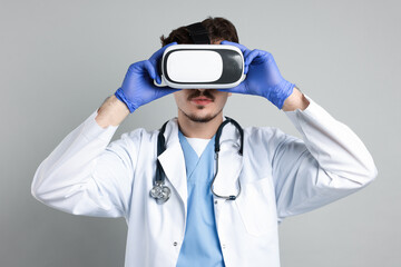 Modern technology. Doctor using virtual reality headset on grey background