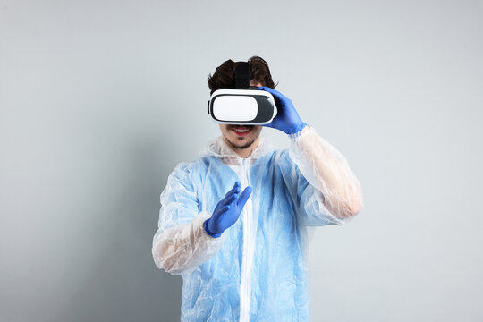 Modern technology. Doctor using virtual reality headset on grey background