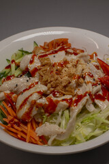 A delicious and satisfying bowl of fresh salad filled with tender chicken, vibrant vegetables, and a flavorful sauce