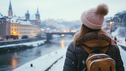 Traveler exploring a snowy cityscape by the river in winter