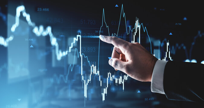 Business hand pointing at rising financial chart with blue glowing lines and forex data on futuristic digital interface background in trading concept.