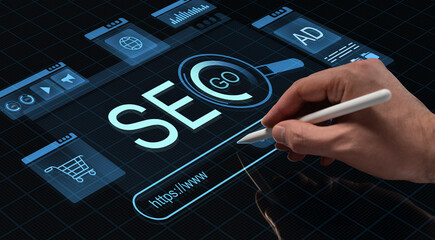 Person using stylus pen to interact with digital SEO interface on futuristic HUD screen with business and technology icons on dark background.