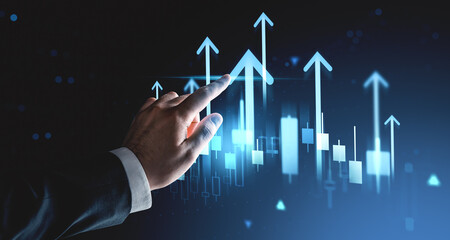 Businessman's hand touching upward arrows and candlestick chart symbols on futuristic digital interface background representing stock market growth concept.