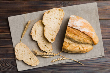 Freshly baked bread slices on napkin against natural background. top view Sliced bread