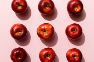 Many red apples on colored background, top view. Autumn pattern with fresh apple above view