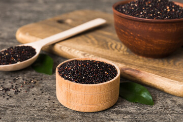 quinoa seeds in bowl and spoon on colored background. Healthy kinwa in small bowl. Healthy superfood