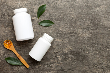 Omega-3 capsules lie in white bottle on a table with green leaves background. Fish oil tablets. Biologically active additives. omega 6, omega 9, vitamin A, E, D, vitamin D3 top view with copy space