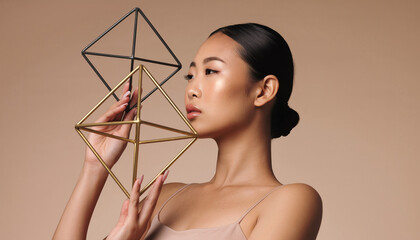 Elegant woman with geometric sculpture, showcasing beauty and sophisticated style in a studio setting, perfect for branding and design concepts