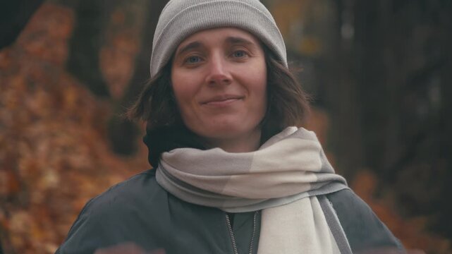 Smile: A Beautiful Slavic Woman in a Beanie and Scarf Surrounded by Colorful Autumn Leaves, Showcasing Reflective Expressions and a Serene Connection with Nature