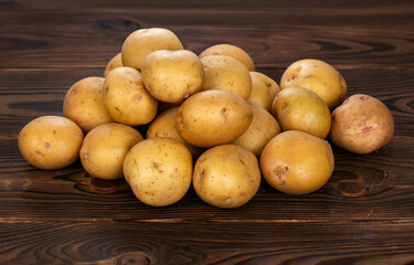 Raw fresh potatoes on wooden boards
