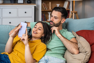Couple relaxes together, taking a selfie on a smartphone, laughing at messages, sharing photos, scrolling the feed, planning weekend, replying to friends, and saving moments to the gallery today
