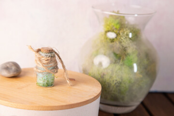 Mini Glass Bottles With Twine, Moss, And Natural Decorative Jar On Wooden Surface