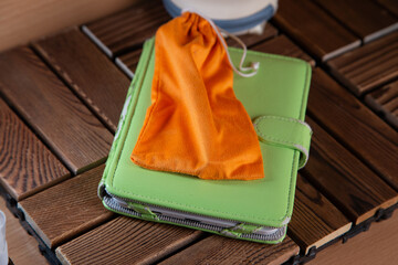 Green Wallet With Orange Cloth On Wooden Table. Travel Organizer And Accessory