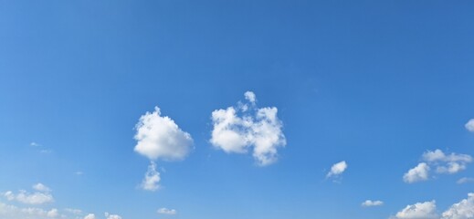 Beautiful blue sky with fluffy white clouds and copy space for background