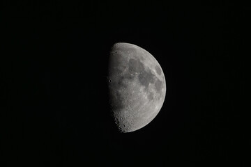 First quarter moon in night sky © Michal Plevko