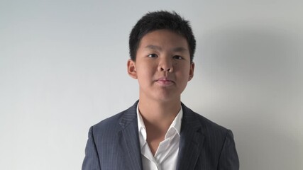 Portrait of Asian teenage boy talking and looking at camera against white background
