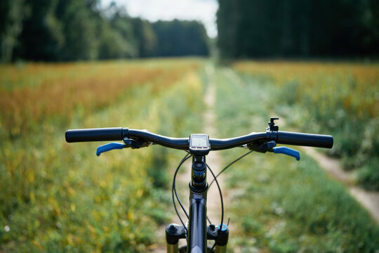 Biker perspective on wooded path outdoors - Powered by Adobe