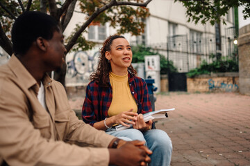 Two college students studying together outdoors on campus