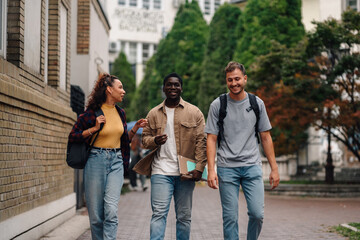 Happy university students walking and talking on campus
