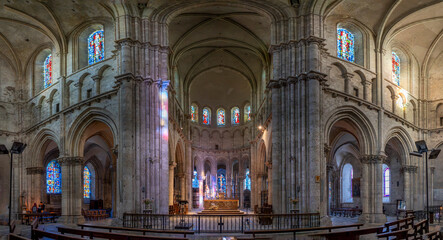 Obraz premium Blois, France - 10 26 2025: Saint Nicholas Church. Panoramic view of the transept with stained glass windows and altar at the back