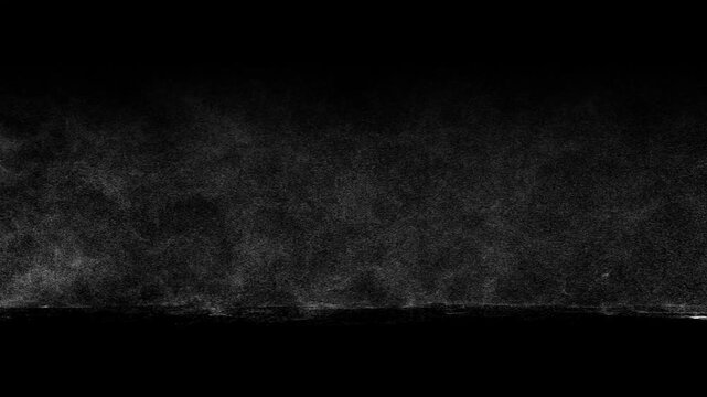 White dust or snow blows horizontally across ground on black background. Ideal for blizzard, sandstorm, or windy weather overlays