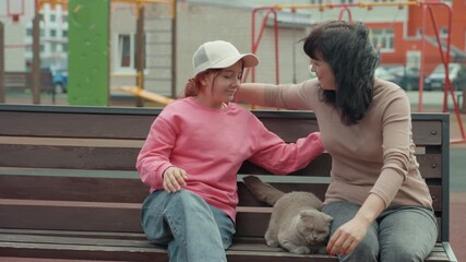 Teenager On Bench Laughing With Pet While Neighbor Leans In To Join Playful Moment, City Playground Backdrop, Casual Pink Sweater And Cap, Joyful Interaction, Light Afternoon Breeze, Affectionate