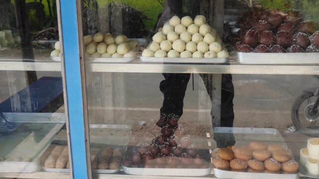 variety of traditional Indian sweets, known as mithai, for sale in a glass display case
