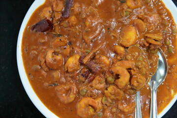 Close up of Kerala style Prawn masala with two spoons on table in a local restaurant at Thekkady, Kerala, India