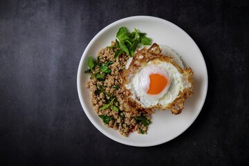 Stir-fried minced chicken with holy basil served with steamed rice and fried egg.