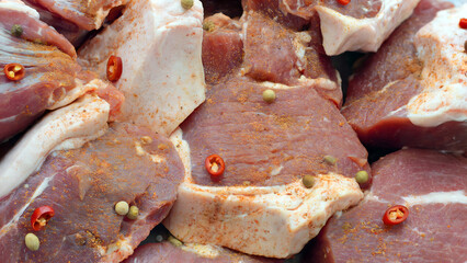 Fresh raw pork cuts seasoned with spices and chili slices cooking preparation